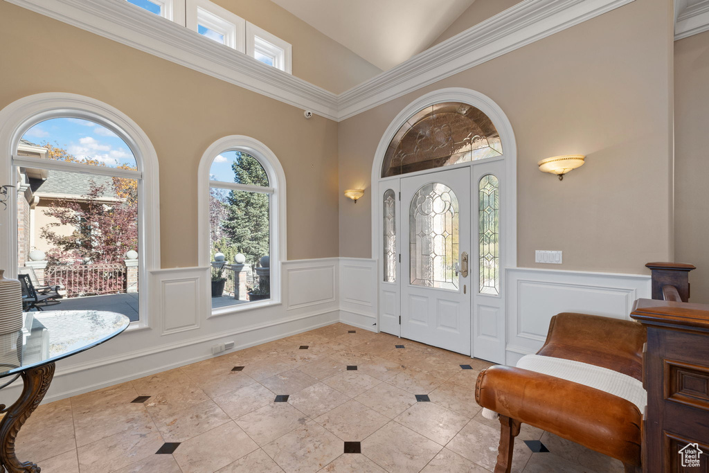 Entryway with ornamental molding and high vaulted ceiling