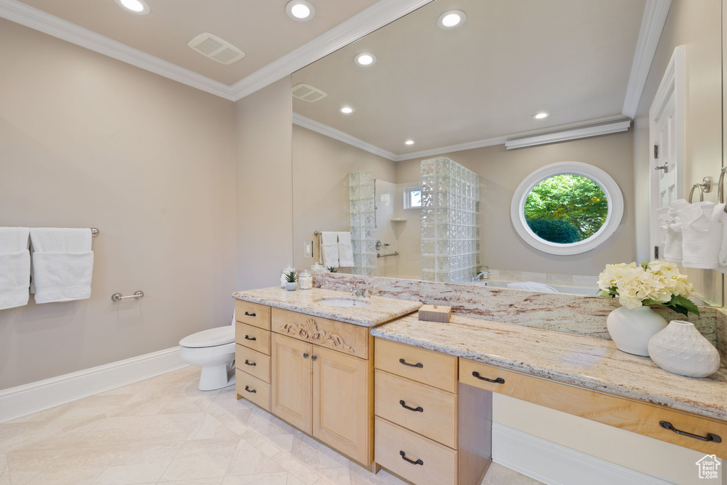 Bathroom featuring tile patterned floors, ornamental molding, vanity, toilet, and a shower