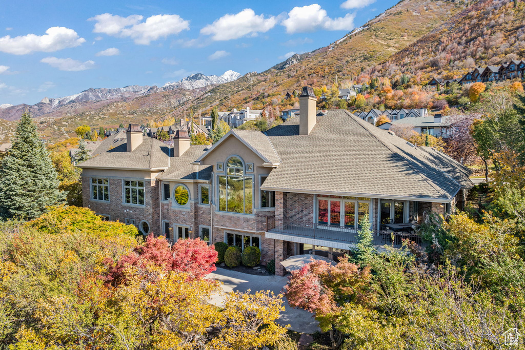 Back of property with a mountain view and a carport