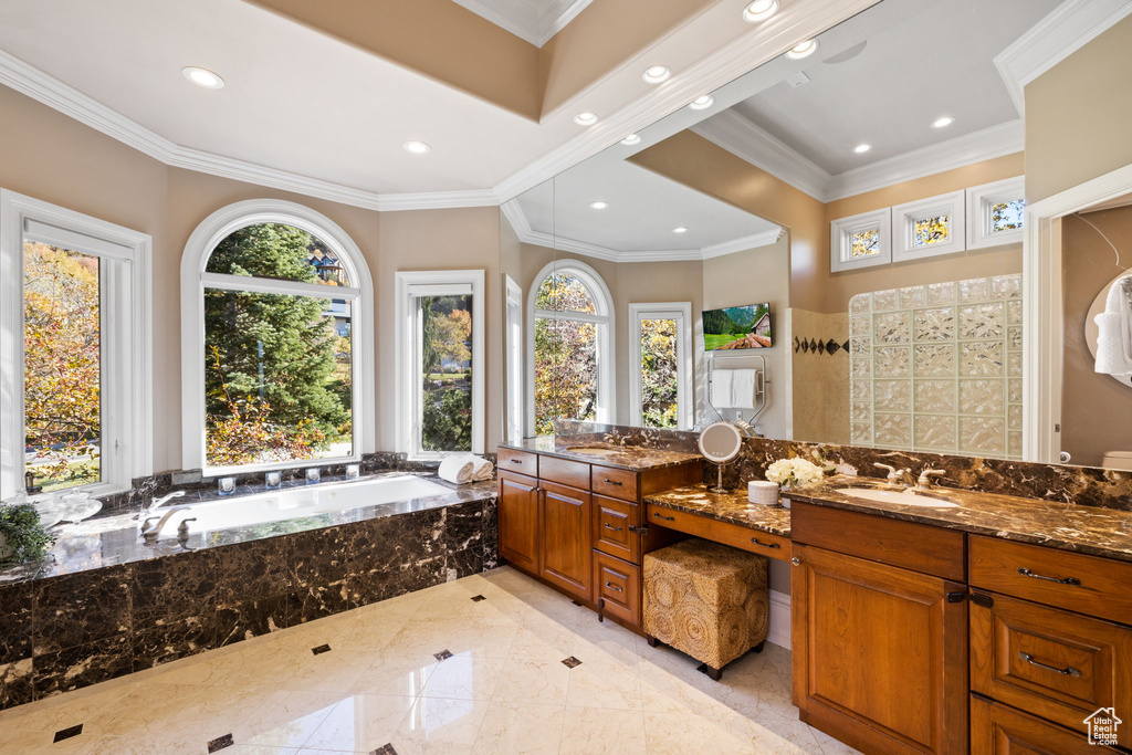 Bathroom with a wealth of natural light, tiled bath, and crown molding