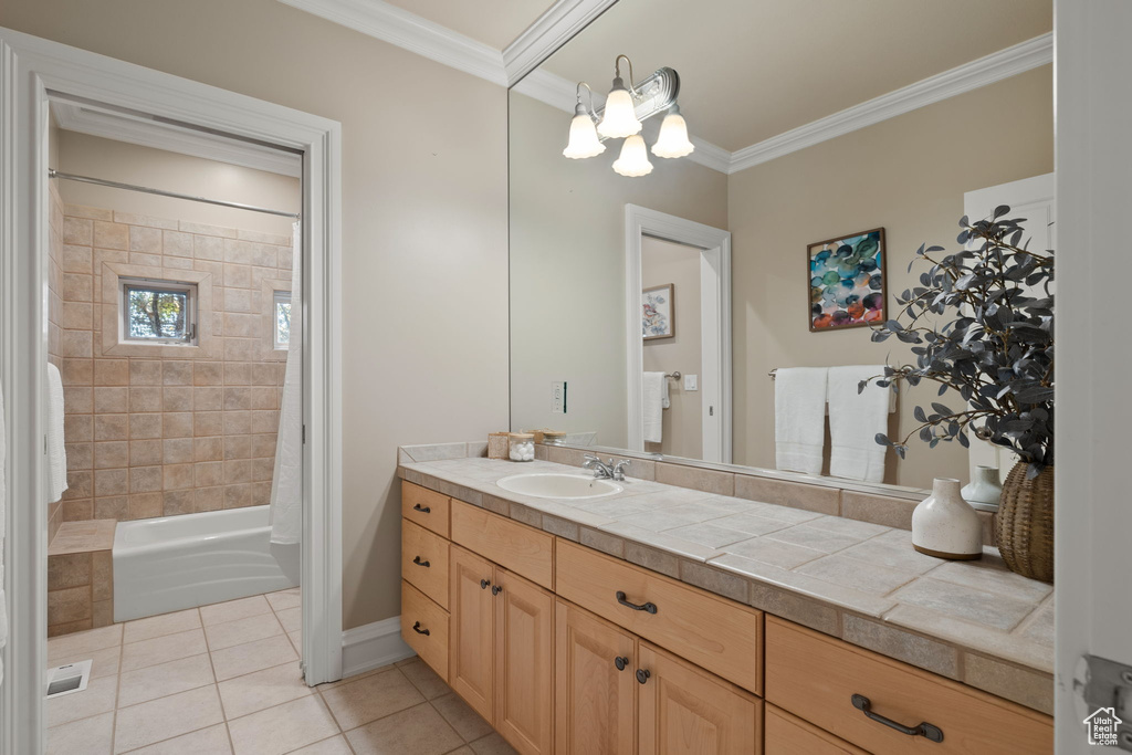 Bathroom with tile patterned flooring, ornamental molding, a chandelier, vanity, and shower / bath combo