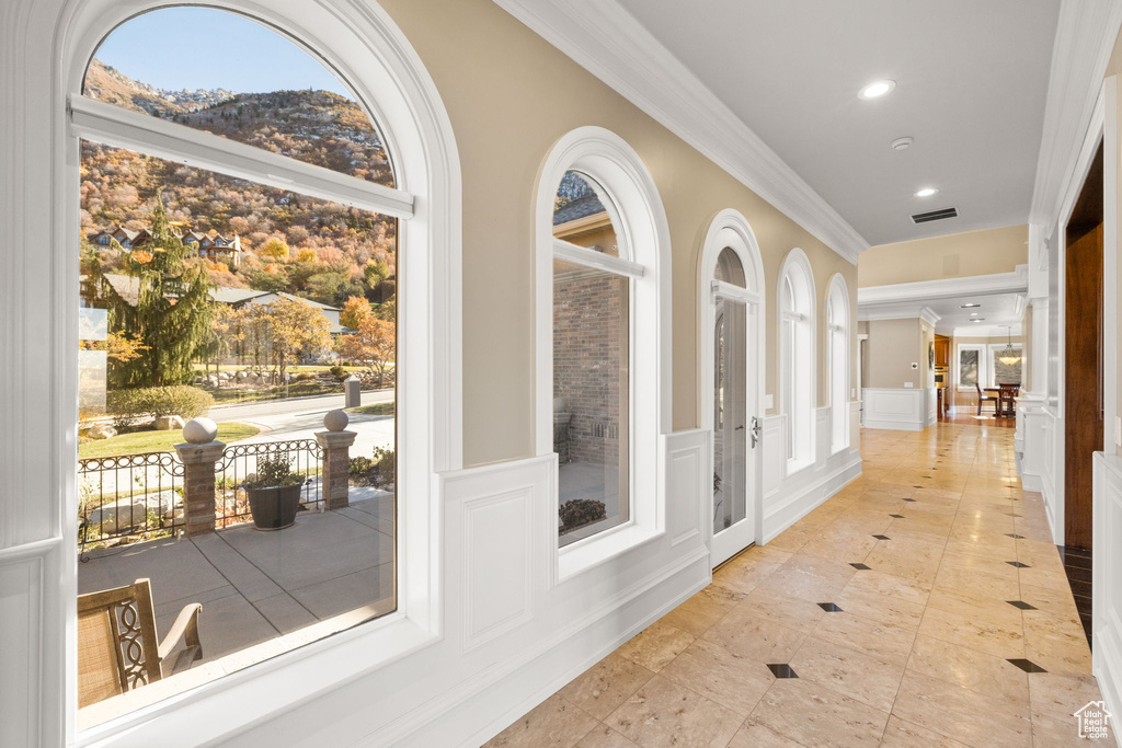 Corridor featuring a mountain view and ornamental molding