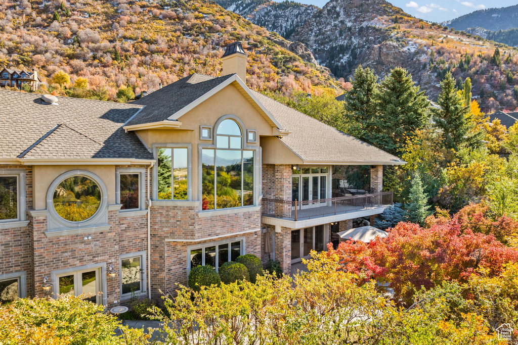 Back of house featuring a mountain view and a balcony