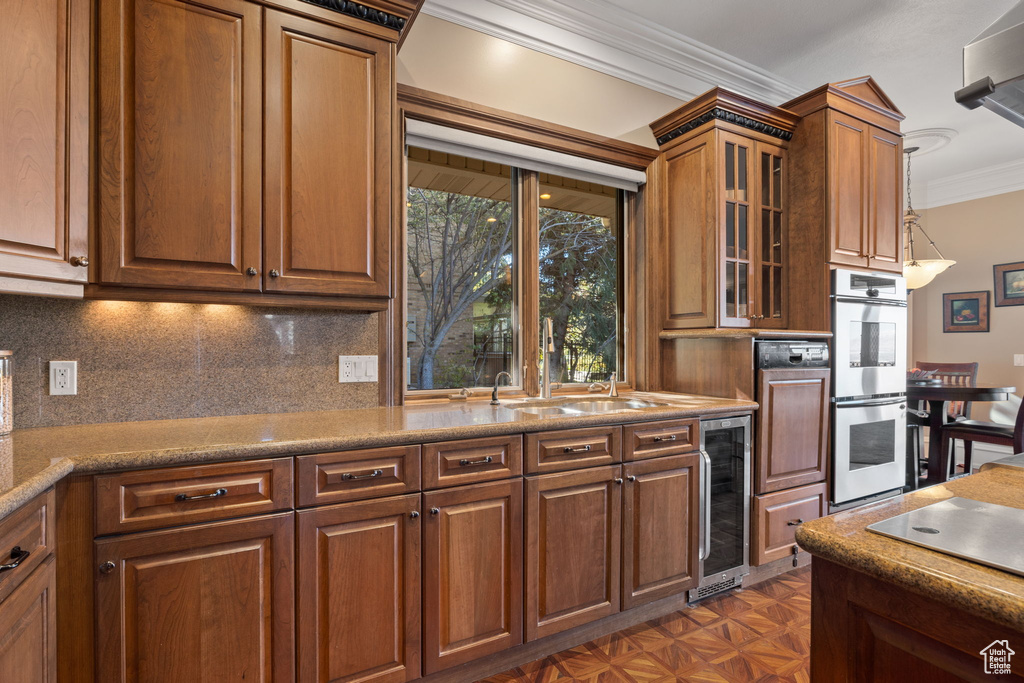 Kitchen featuring ornamental molding, backsplash, dark parquet floors, beverage cooler, and double oven