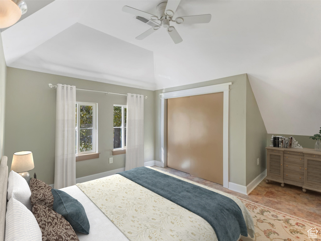 Bedroom featuring a ceiling fan, lofted ceiling, and baseboards