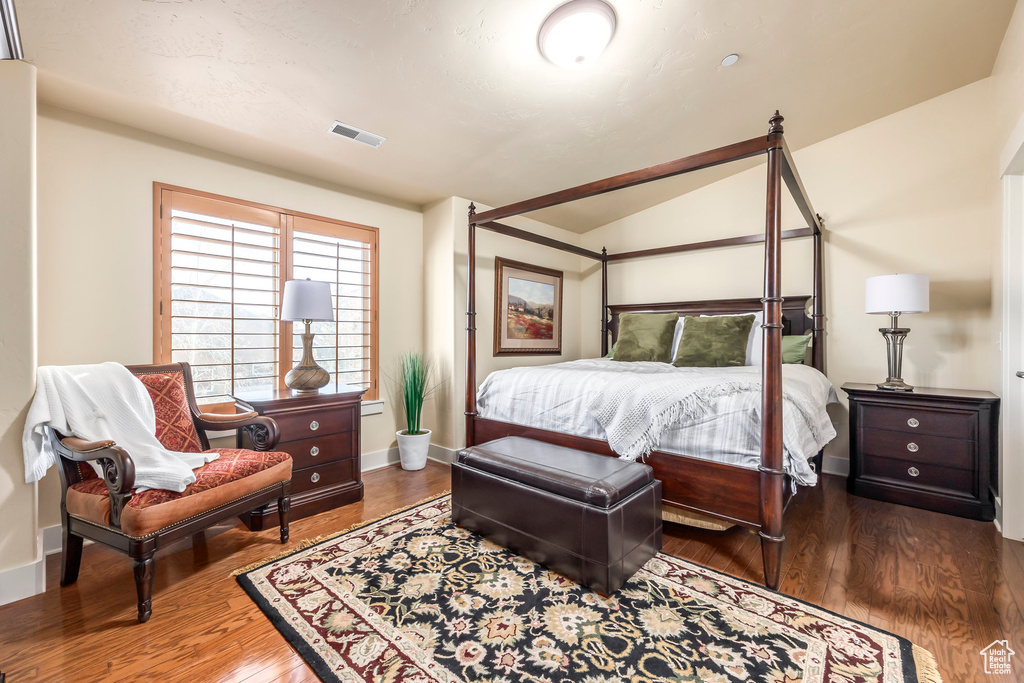 Bedroom featuring lofted ceiling and hardwood / wood-style flooring