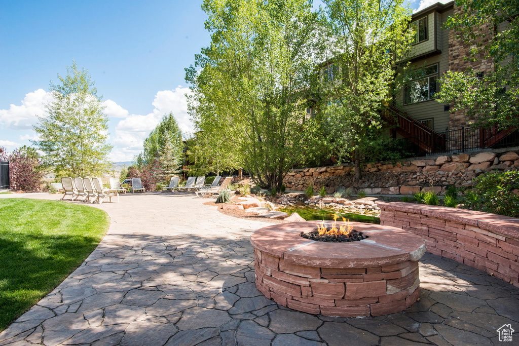 View of home's community with an outdoor fire pit and a patio