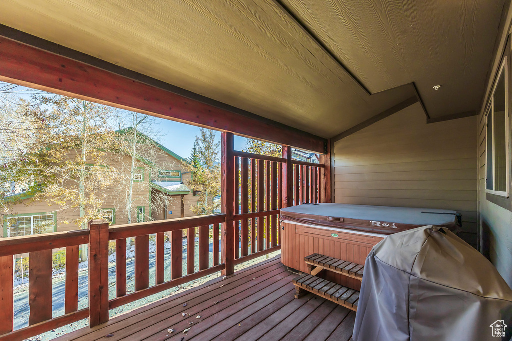 Wooden deck with a grill and a hot tub