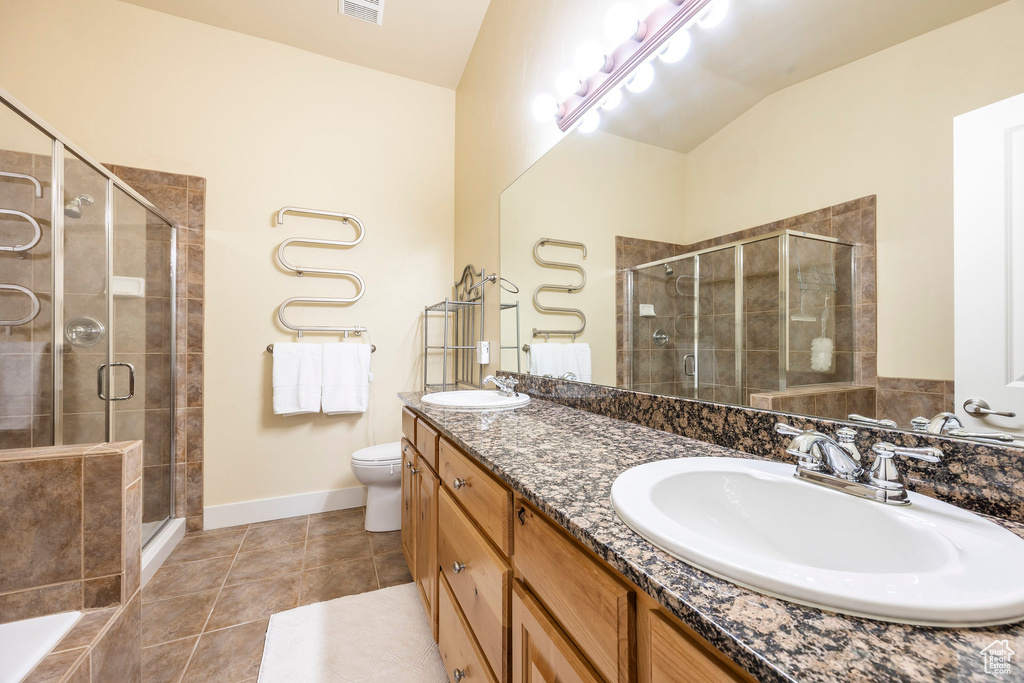 Full bathroom with lofted ceiling, toilet, tile patterned floors, plus walk in shower, and vanity