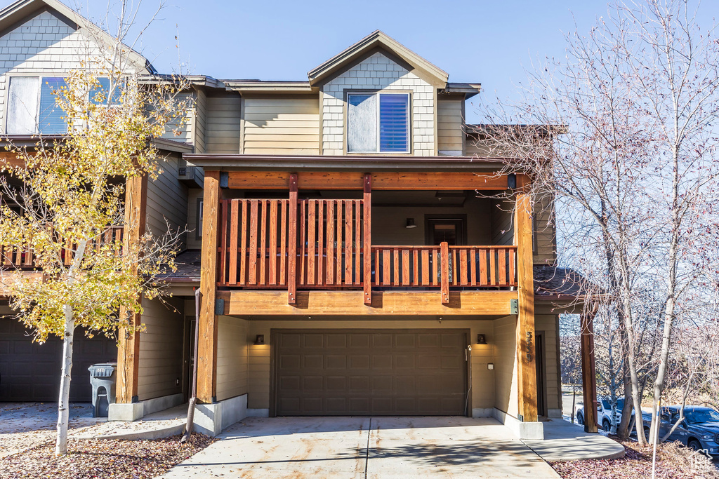 View of front of property with a garage and a balcony