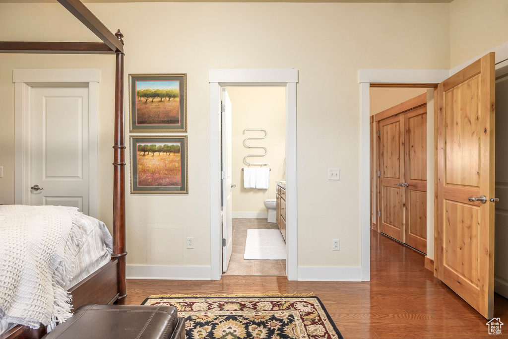 Bedroom featuring dark hardwood / wood-style flooring and ensuite bath