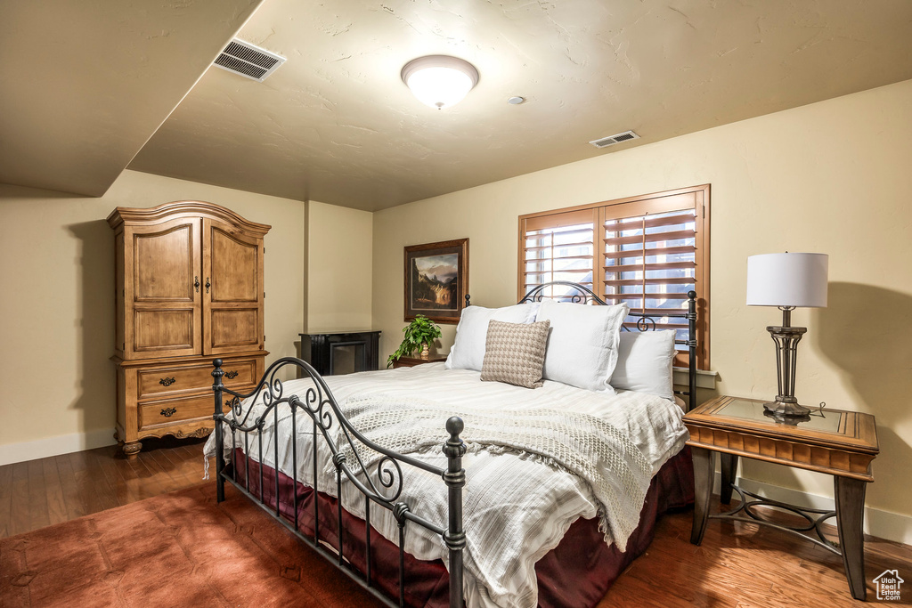 Bedroom with dark hardwood / wood-style flooring