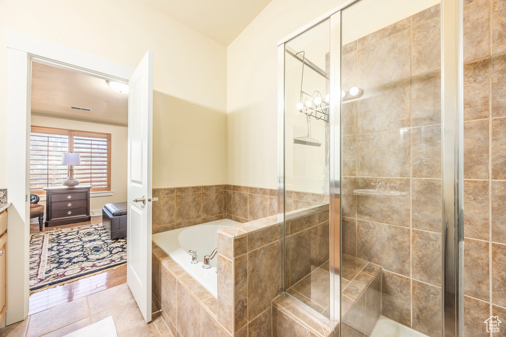 Bathroom with independent shower and bath and tile patterned floors