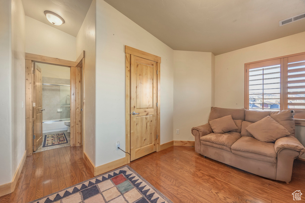 Living room with wood-type flooring and vaulted ceiling