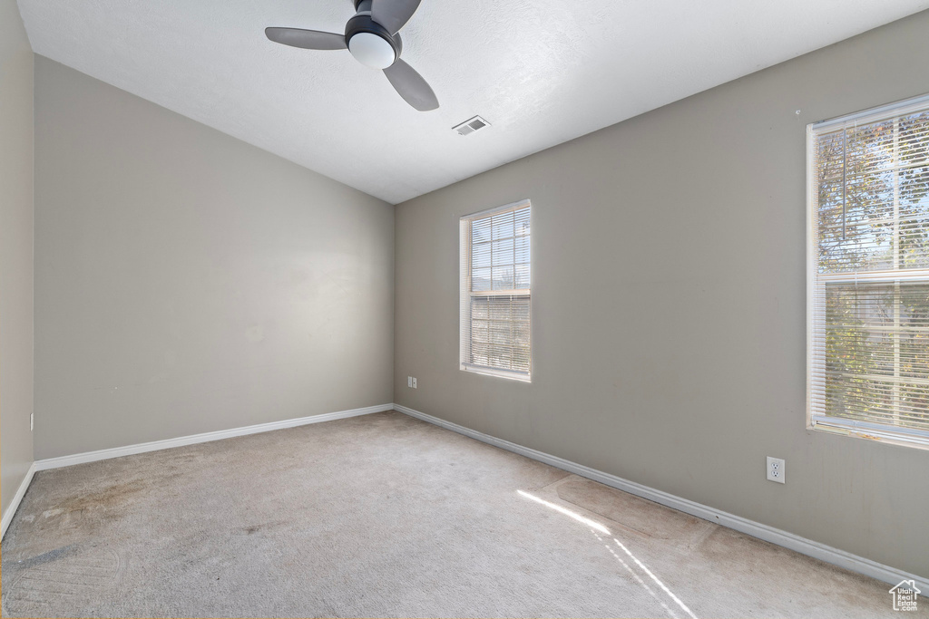 Carpeted empty room with ceiling fan