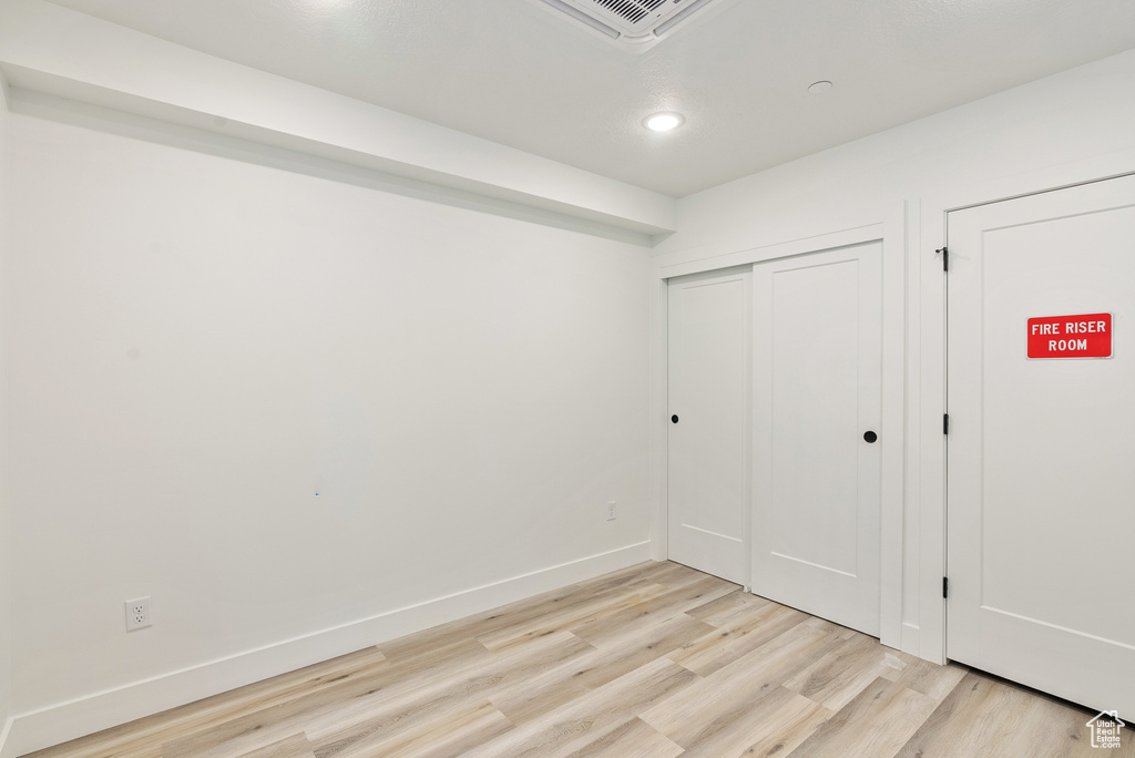 Unfurnished bedroom with light wood-type flooring and a closet