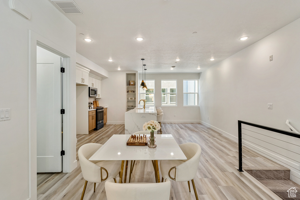 Dining room with light hardwood / wood-style flooring