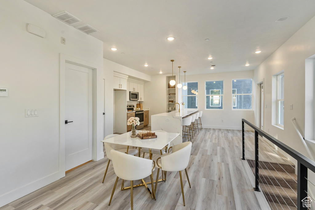 Dining area with light hardwood / wood-style floors and sink