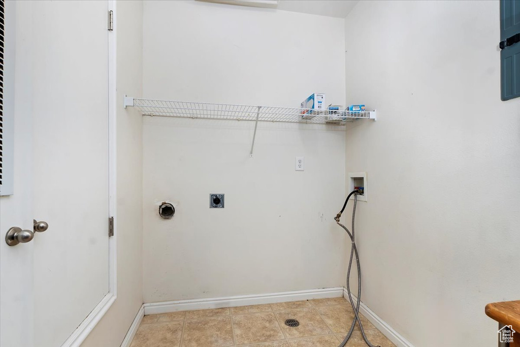 Laundry room with light tile patterned floors, hookup for a washing machine, laundry area, baseboards, and electric dryer hookup
