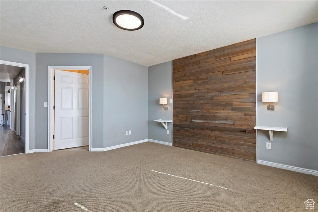 Interior space featuring baseboards, wooden walls, and a textured ceiling