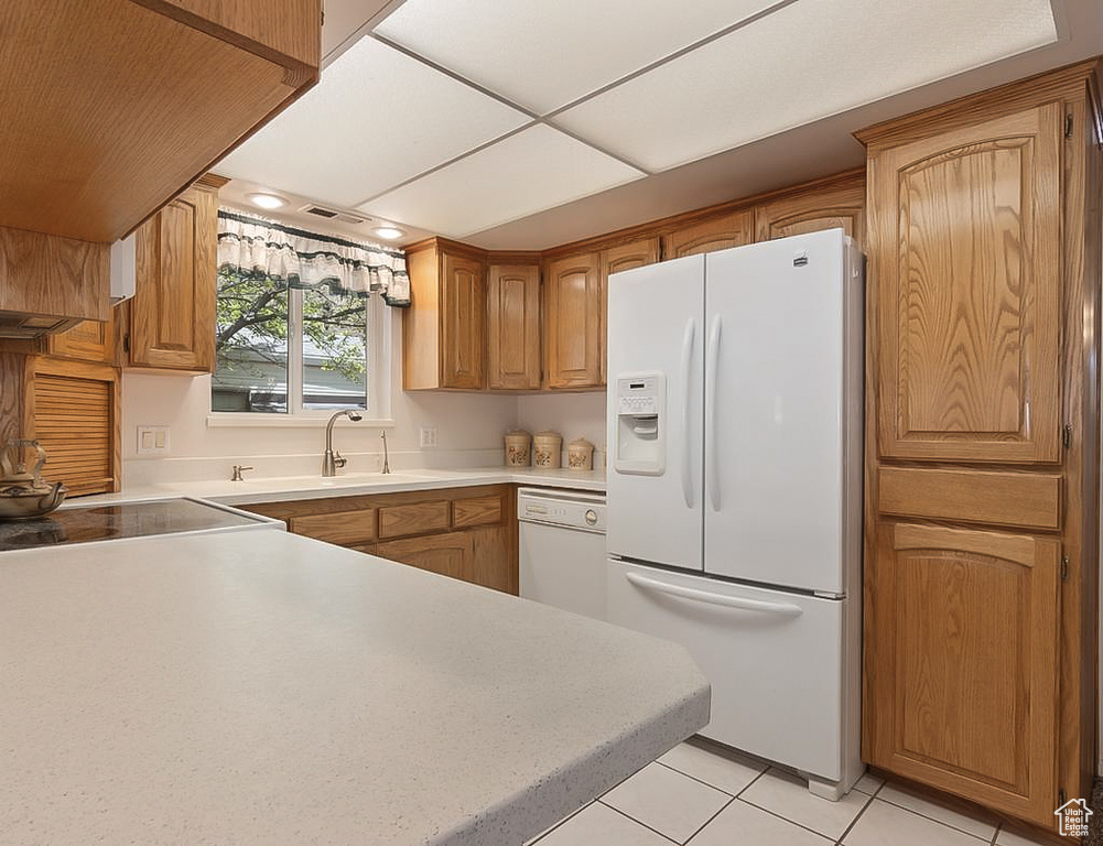 Kitchen featuring a sink, light countertops, white appliances, and light tile patterned flooring
