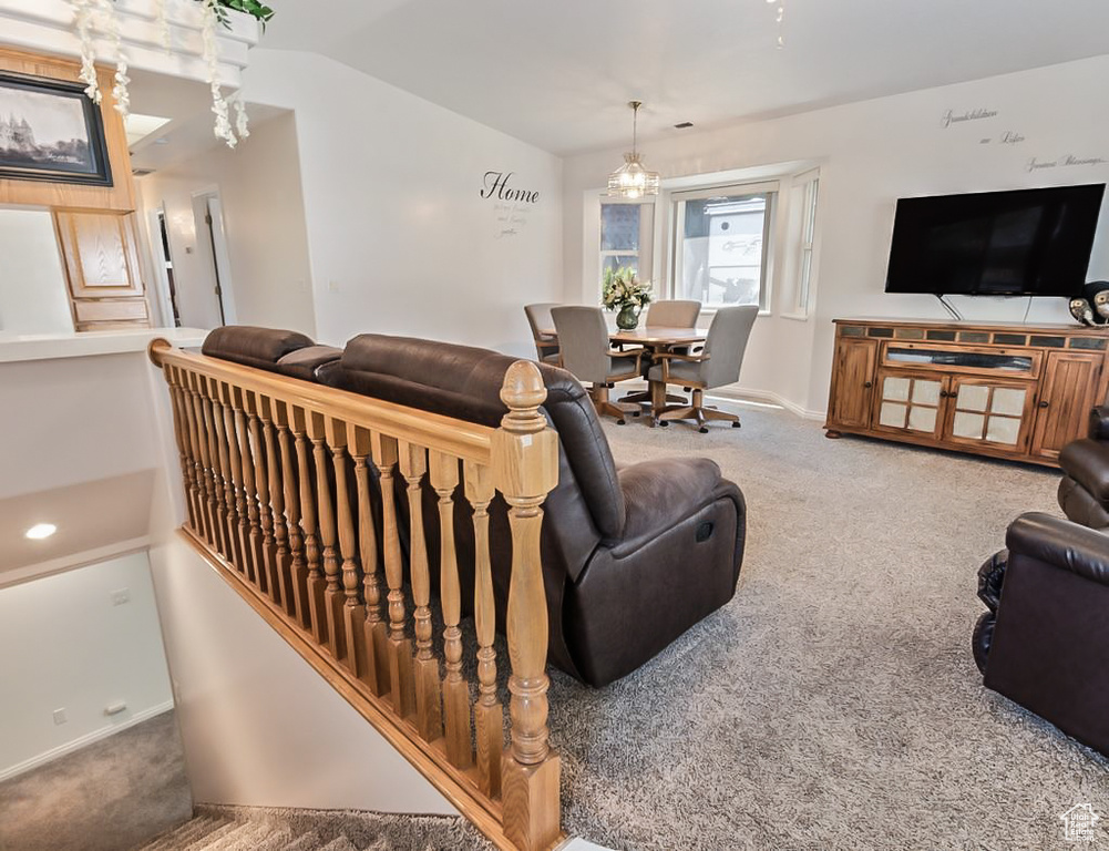 Carpeted living room with baseboards and lofted ceiling
