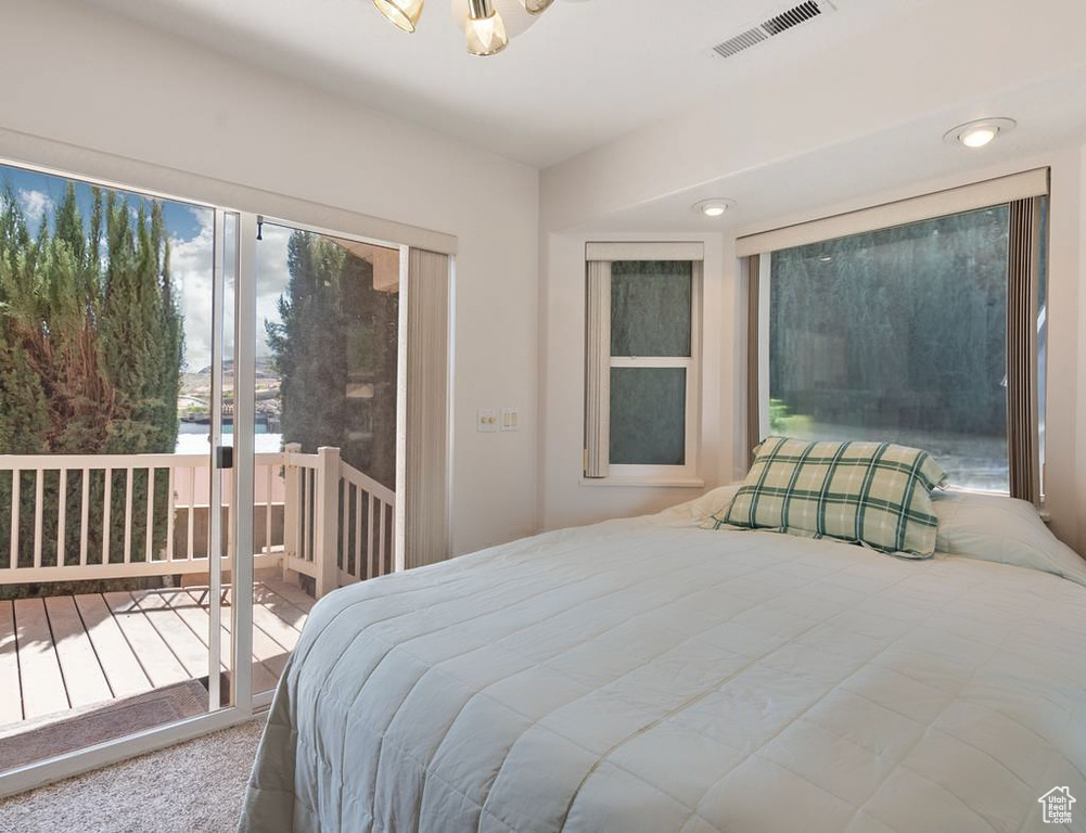 Carpeted bedroom with access to exterior, visible vents, and recessed lighting