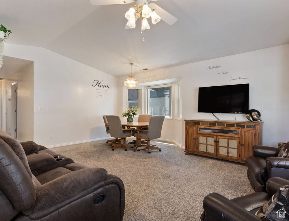 Carpeted living room with baseboards, a ceiling fan, and lofted ceiling