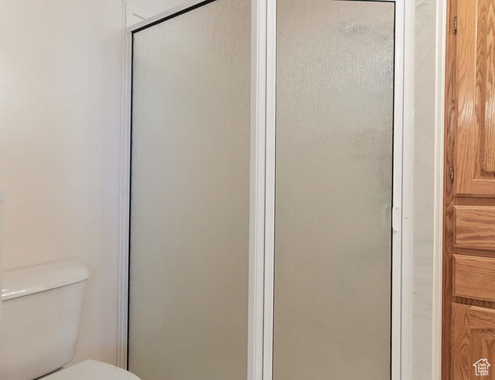 Full bath featuring toilet and a shower stall