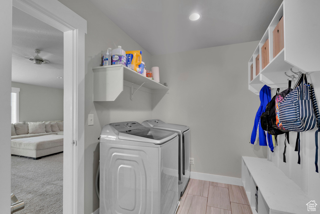 Laundry area featuring light colored carpet and separate washer and dryer