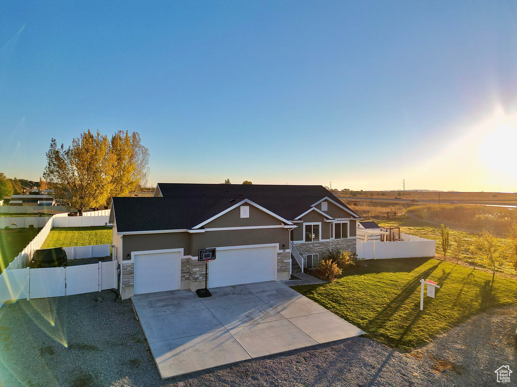 View of front of home featuring a garage and a lawn