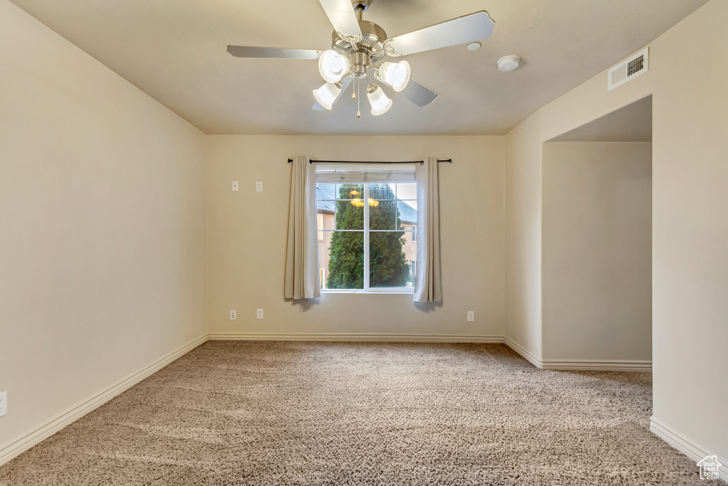 Carpeted spare room with ceiling fan