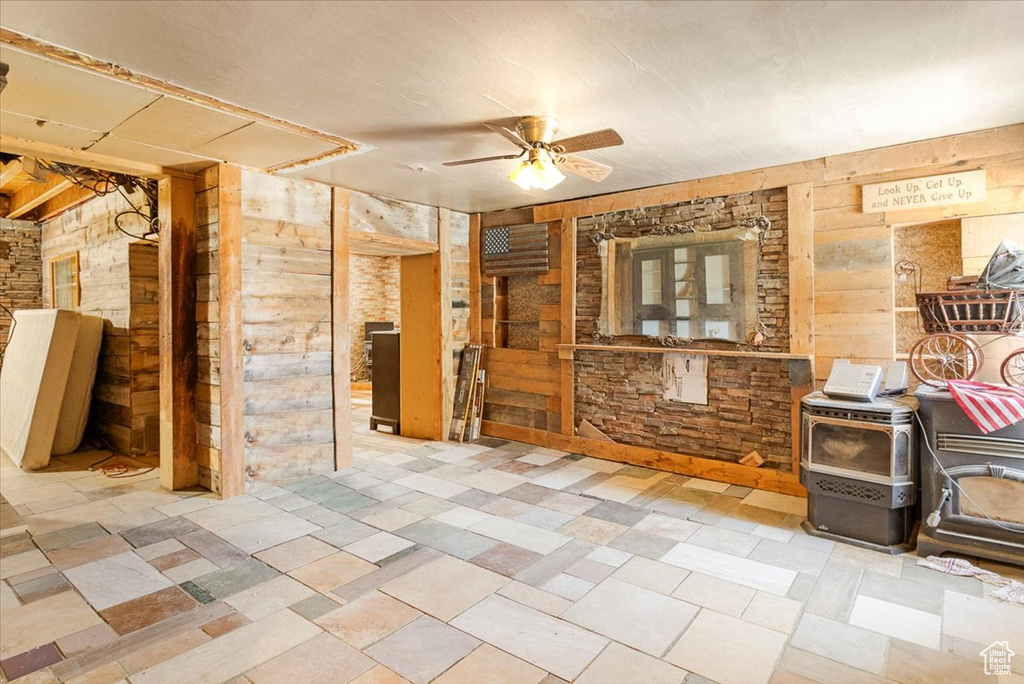 Interior space with a wood stove and ceiling fan