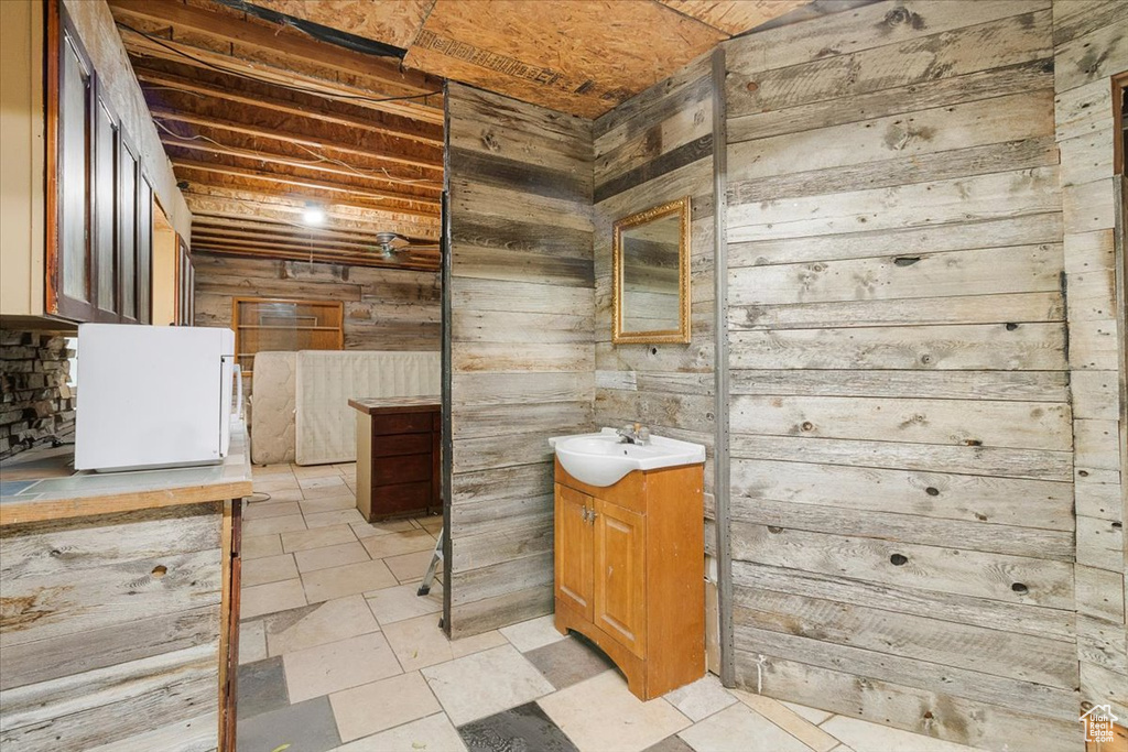 Bathroom featuring wood walls and vanity