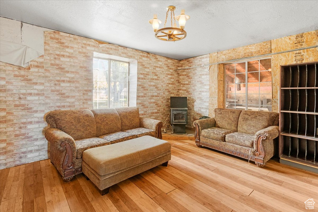Living room featuring a wood stove, hardwood / wood-style flooring, and a textured ceiling