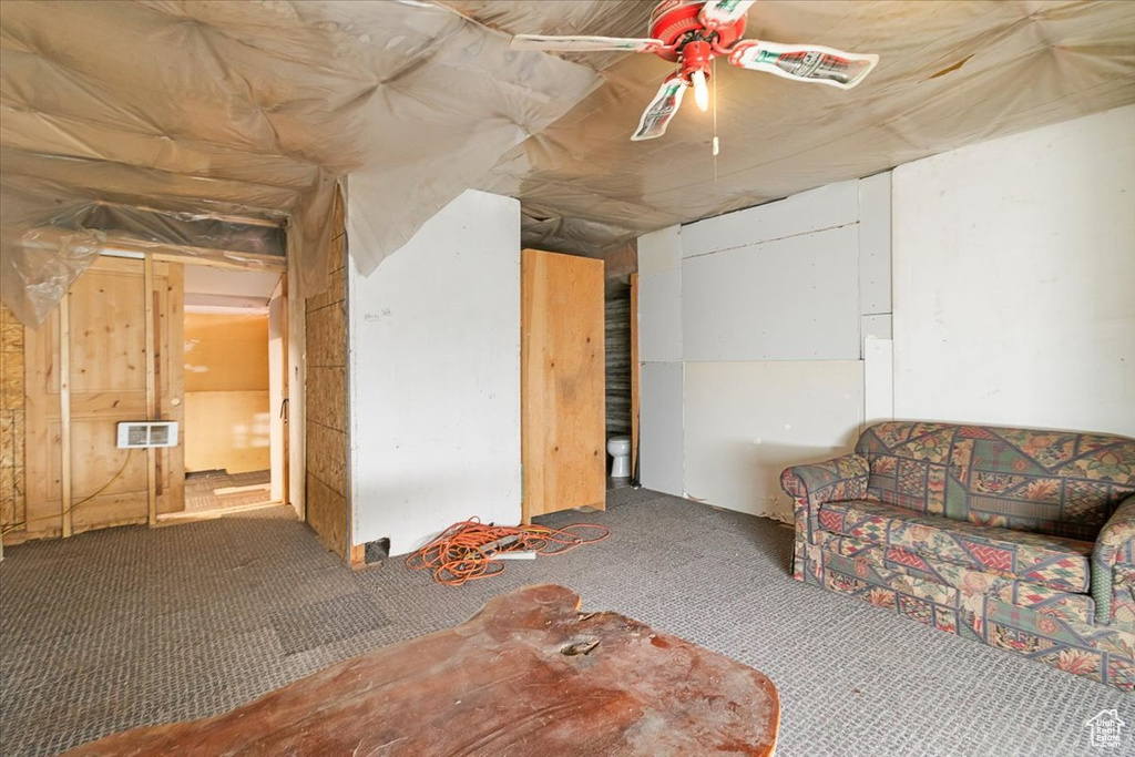 Unfurnished living room featuring carpet and ceiling fan