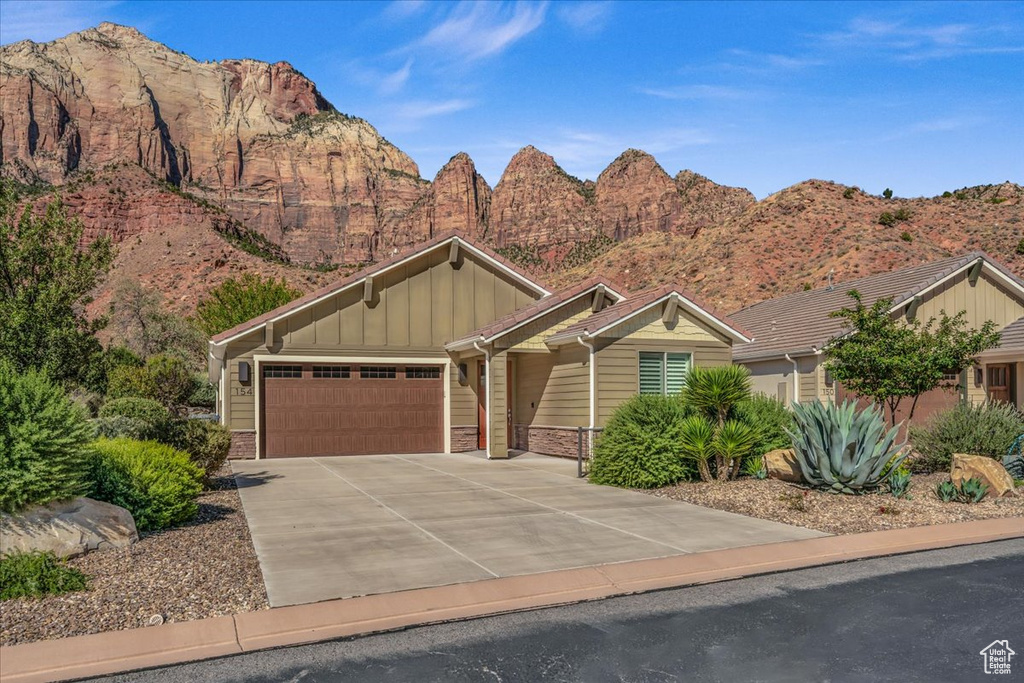 View of front of home with a garage and a mountain view