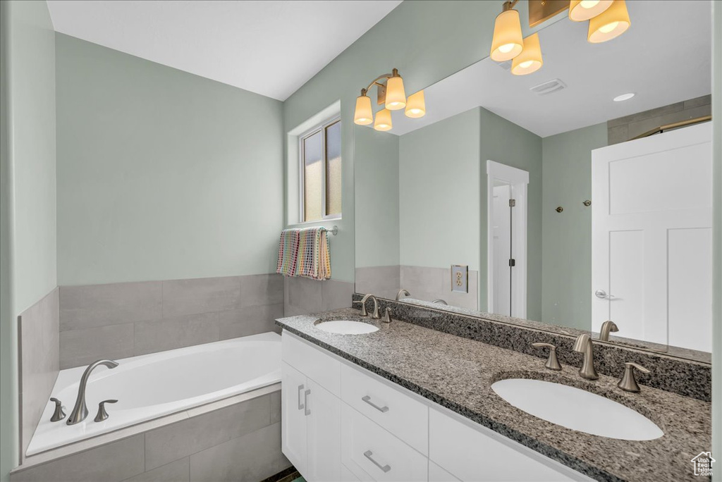 Bathroom featuring vanity and tiled tub