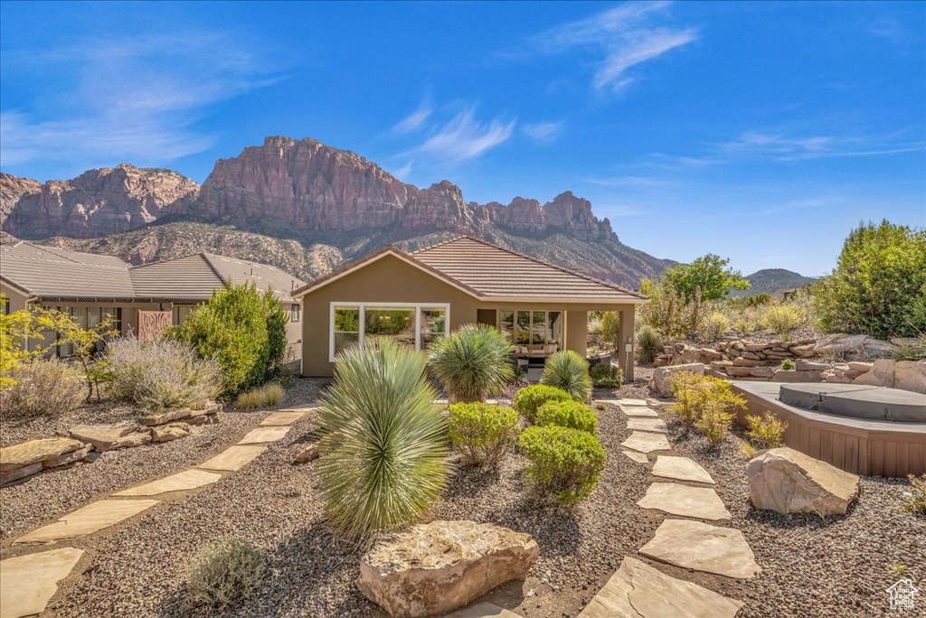 View of front of house featuring a hot tub and a mountain view