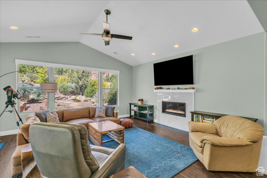 Living room featuring lofted ceiling, dark hardwood / wood-style floors, and ceiling fan