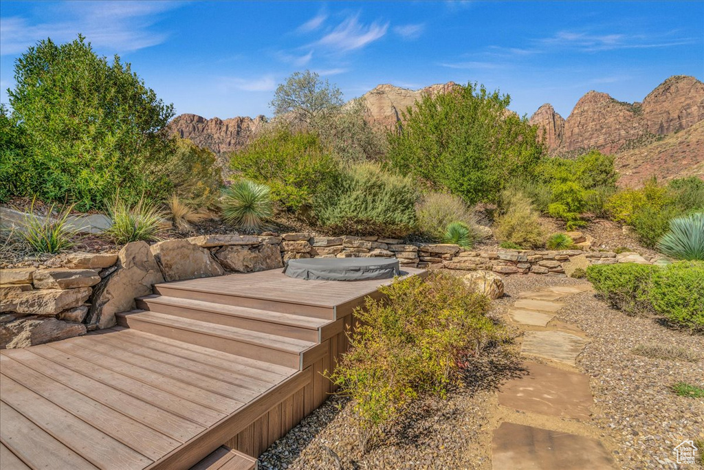 Exterior space with a hot tub and a mountain view