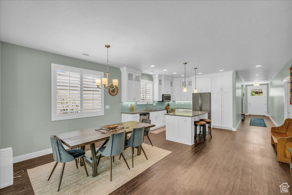 Dining area featuring sink, dark hardwood / wood-style flooring, and a chandelier