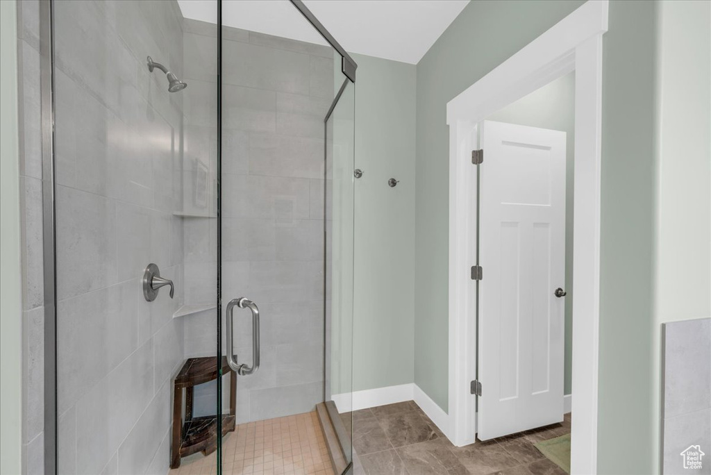 Bathroom with a shower with shower door and tile patterned flooring