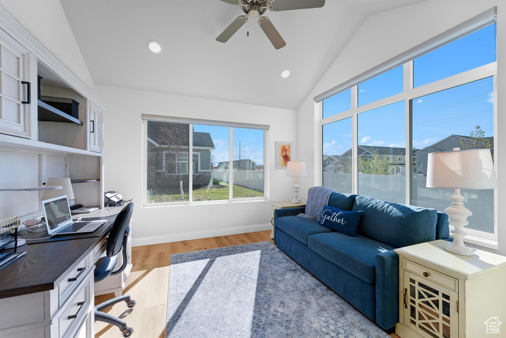 Office area featuring light wood-type flooring, ceiling fan, and vaulted ceiling