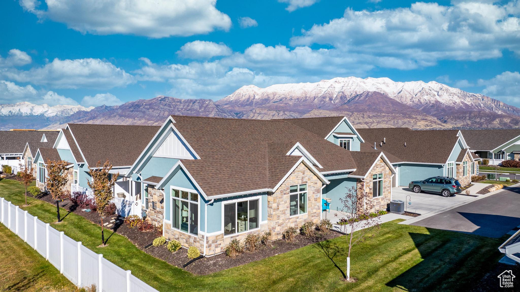 View of front of property featuring central AC unit, a front yard, and a mountain view