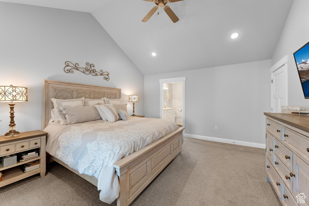Carpeted bedroom featuring ensuite bathroom, ceiling fan, and lofted ceiling