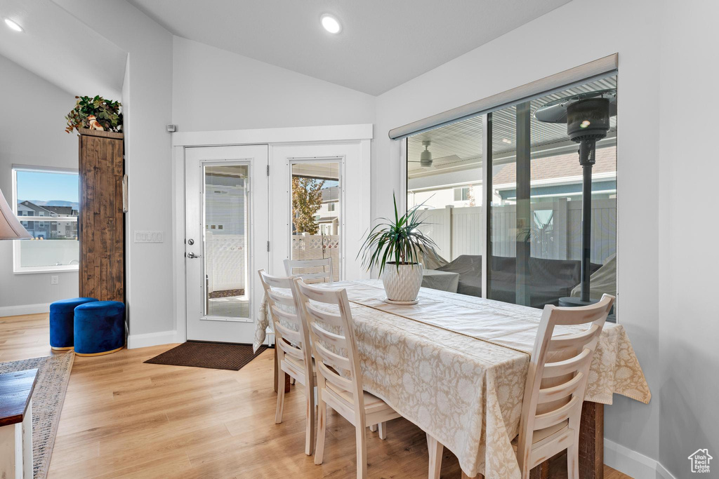 Dining space with light wood-type flooring and vaulted ceiling