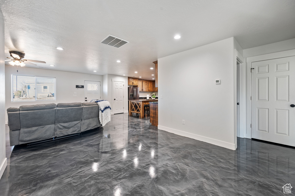 Living room featuring a textured ceiling and ceiling fan