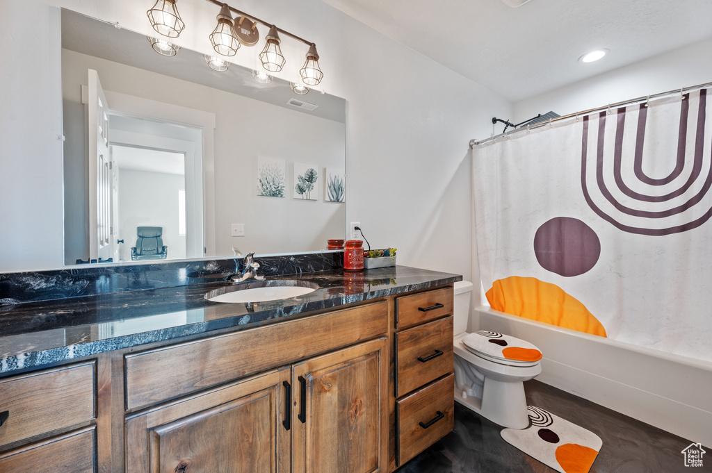 Full bathroom with wood-type flooring, vanity, toilet, and shower / tub combo