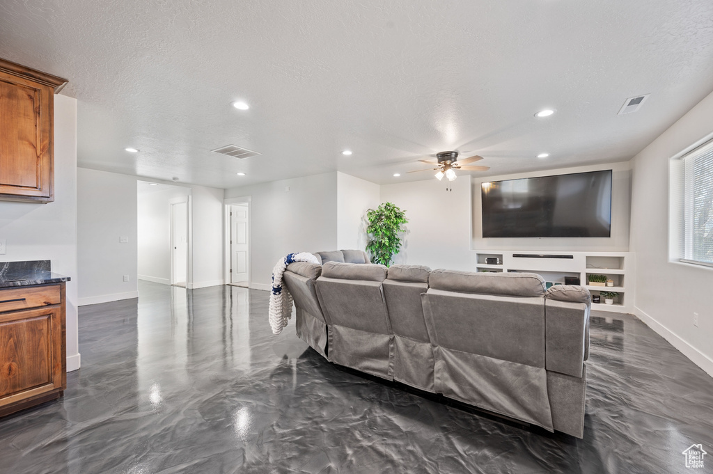 Living room with a textured ceiling and ceiling fan